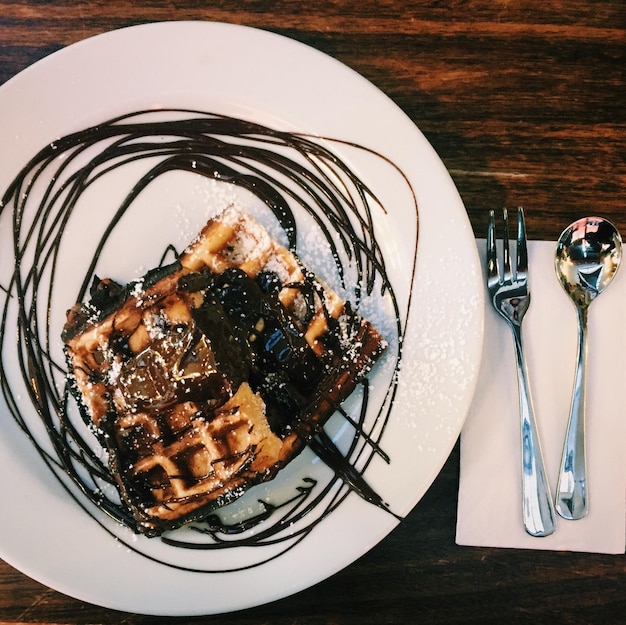 Vista ad alto angolo di waffle al cioccolato in piatto servito sul tavolo