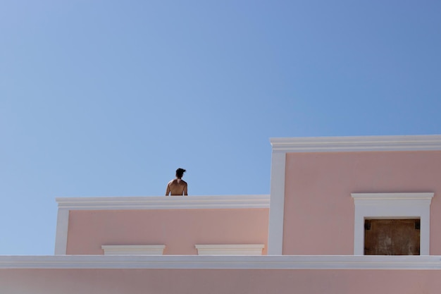 Vista ad angolo basso dell'uomo sulla terrazza contro un cielo limpido