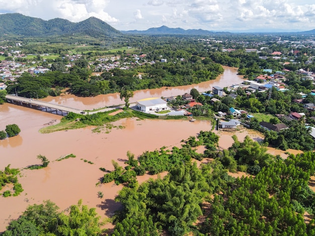 Vista aerea alluvione del fiume villaggio campagna Asia e albero della foresta, vista dall'alto fiume con inondazione d'acqua dall'alto, fiume infuriato che scorre lungo il lago della giungla che scorre acqua selvaggia dopo la pioggia