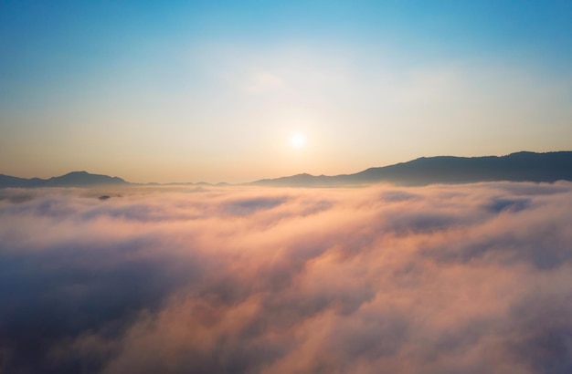 Vista aerea bellissima del paesaggio mattutino mare di nuvole e la nebbia scorre sulle alte montagne