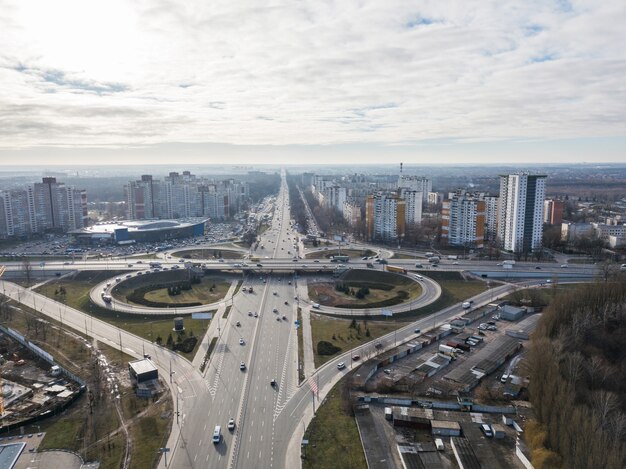 Vista aerea dal drone sulla città con case moderne e un incrocio di piazza Odessa con svincolo stradale a forma di quadrifoglio contro il cielo in una giornata autunnale. Kiev, Ucraina