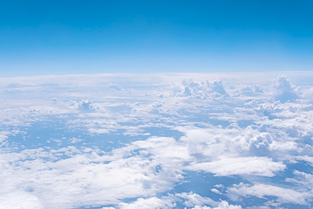 Vista aerea dal finestrino dell'aereo Sopra le nuvole Cielo blu sullo sfondo di molte nuvole