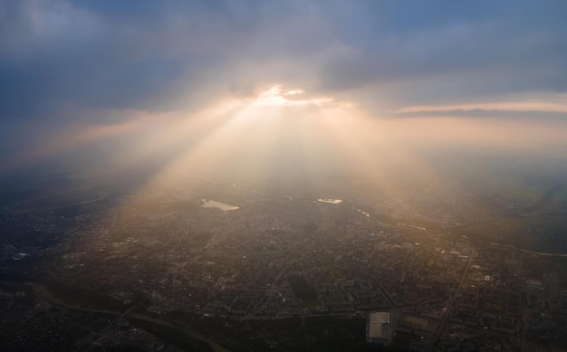 Vista aerea dall'alta altitudine della città lontana ricoperta di nuvole cumuliformi gonfie che si formano prima del temporale in serata. Punto di vista aereo del paesaggio nuvoloso.