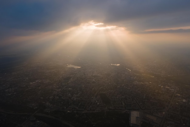 Vista aerea dall'alta quota della città lontana ricoperta di nubi cumuliformi gonfie che si formano prima del temporale in serata. Punto di vista dell'aeroplano del paesaggio nuvoloso