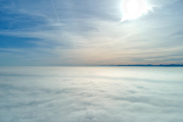 Vista aerea dall'alta quota della terra ricoperta di nubi bianche gonfie in una giornata di sole