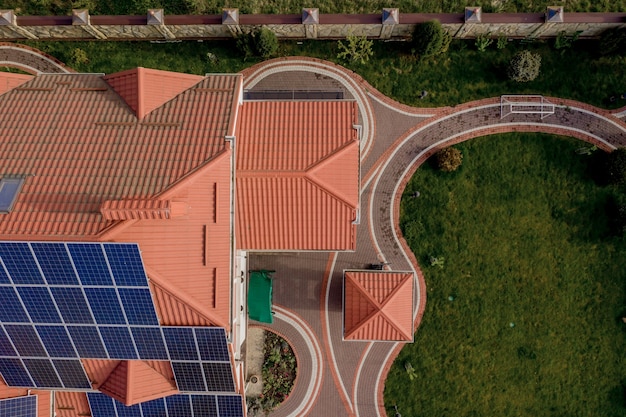 Vista aerea dall'alto del nuovo cottage moderno della casa residenziale con pannelli blu. Concetto di produzione di energia verde ecologica rinnovabile.