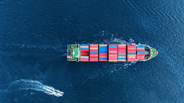 Vista aerea dall'alto della nave da carico che trasporta container e funziona con la barca pilota per l'esportazione di merci dal porto del cantiere di carico al commerciante logistico di trasporto di tecnologia di concetto oceanico personalizzato blobal