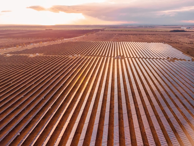 Vista aerea dall'alto di una centrale elettrica di pannelli solari pannelli solari fotovoltaici all'alba e al tramonto in