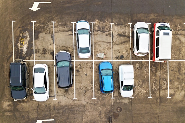 Vista aerea dall'alto in basso di molte auto in un parcheggio di un supermercato o in vendita sul mercato del concessionario auto.