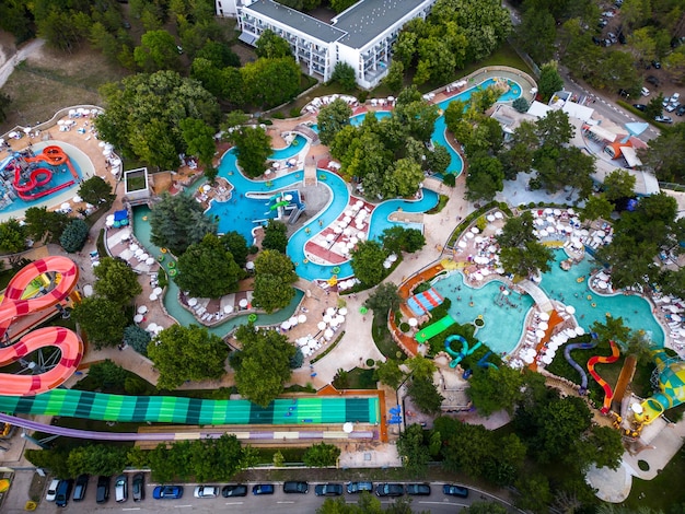 Vista aerea dall'alto in basso di una scena vibrante di un parco acquatico dall'alto dove le persone si divertono con scivoli e piscine Risate e gioia riempiono l'aria