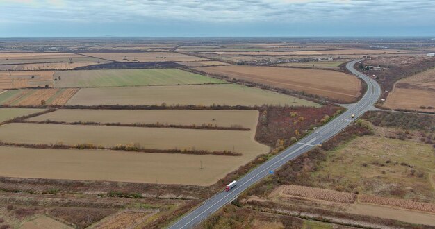 Vista aerea dall'alto su strada tra campi agricoli durante un tardo autunno