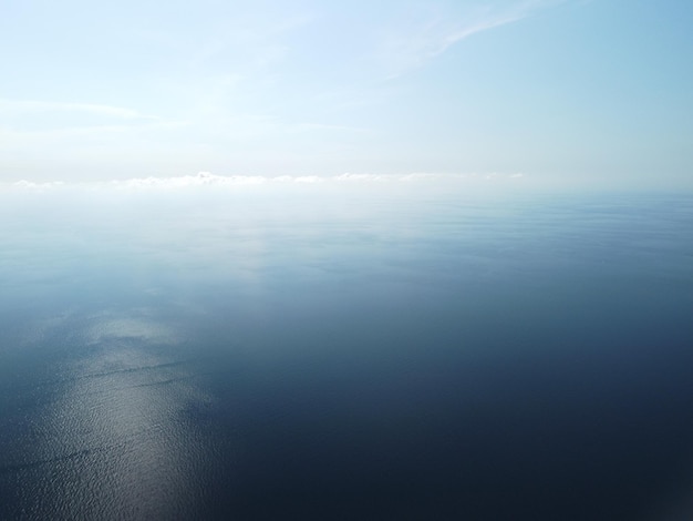 Vista aerea dall'alto sul mare azzurro calmo e sulle sponde rocciose vulcaniche piccole onde sulla superficie dell'acqua in