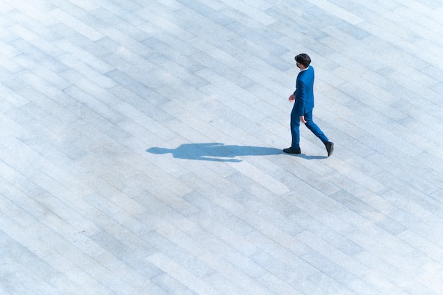 vista aerea dall'alto uomini d'affari camminano sul cemento pedonale con ombra sul terreno