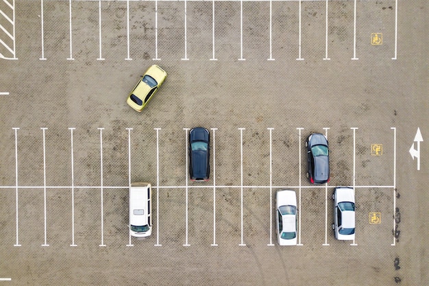 Vista aerea dall'alto verso il basso di molte auto su un parcheggio di un supermercato o sul mercato dei rivenditori di auto in vendita.