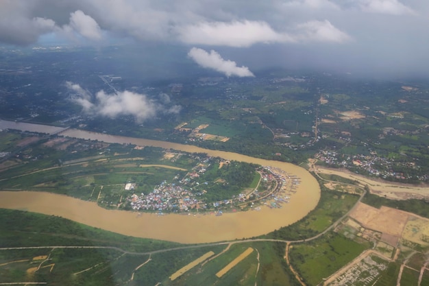 Vista aerea dalla finestra degli aeroplani con terreno agricolo e fiume in una giornata di pioggia Natura e trasporti