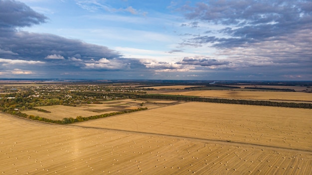 Vista aerea dei campi di cereali dopo il raccolto con pagliaio e battistrada del trattore