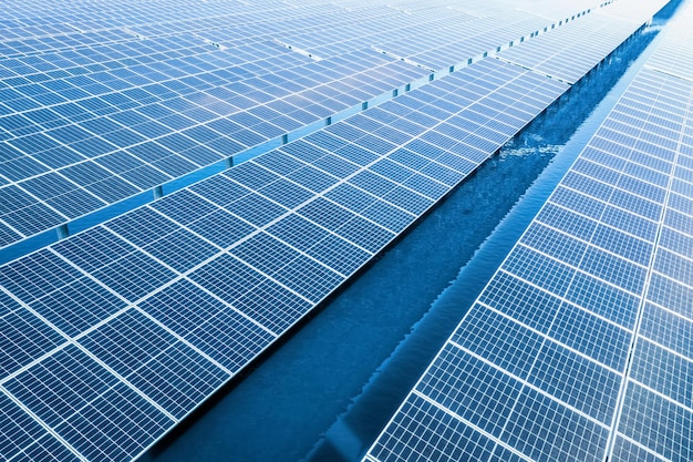 Vista aerea dei pannelli solari della stazione di generazione di energia pulita sulla superficie dell'acqua blu