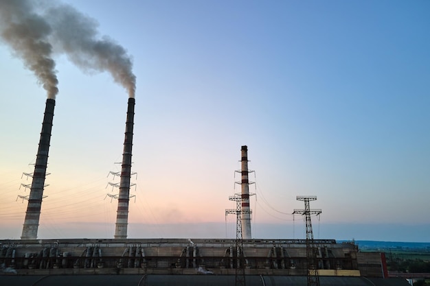Vista aerea dei tubi alti della centrale a carbone con atmosfera inquinante da ciminiera nera Produzione di elettricità con il concetto di combustibile fossile