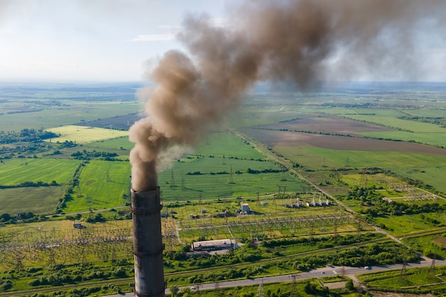 Vista aerea dei tubi alti della centrale elettrica a carbone con atmosfera inquinante del fumaiolo nero. Produzione di elettricità con il concetto di combustibili fossili.