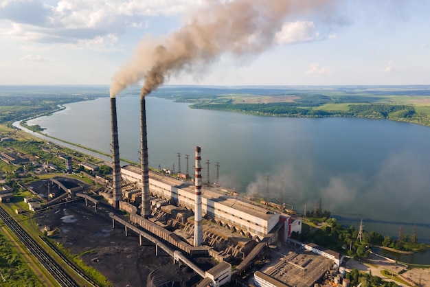 Vista aerea dei tubi alti della centrale elettrica a carbone con atmosfera inquinante del fumaiolo nero. Produzione di elettricità con il concetto di combustibili fossili.