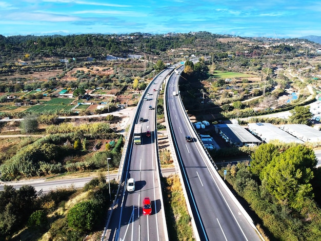 Vista aerea dei veicoli su una lunga autostrada urbana sotto un cielo soleggiato