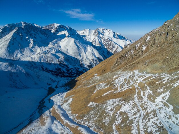 Vista aerea del bosco innevato con una strada. Catturato dall'alto con un drone.