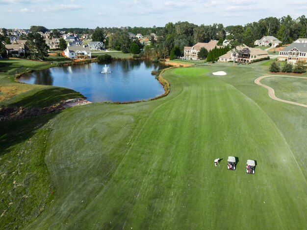 Vista aerea del campo da golf con golf cart in riva al lago