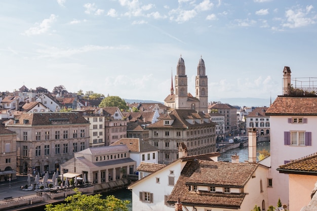 Vista aerea del centro storico di Zurigo con la famosa chiesa Grossmunster e il fiume Limmat dal parco Lindenhof, Zurigo, Svizzera. Paesaggio estivo, tempo soleggiato, cielo azzurro e giornata di sole