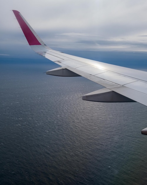 Vista aerea del cielo e delle nuvole della sera sopra l'oceano dall'oblò dell'aeroplano