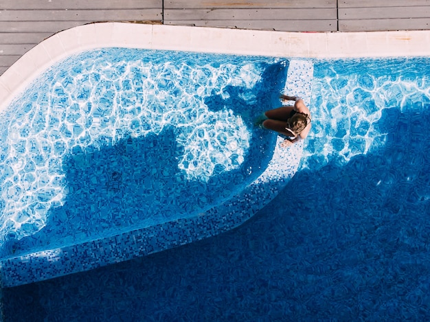 Vista aerea del drone della donna in piscina in hotel