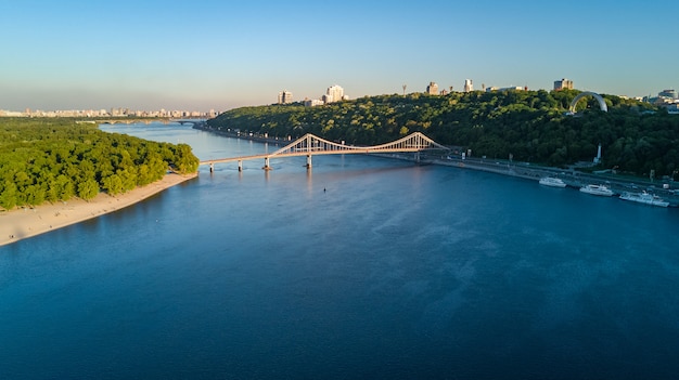 Vista aerea del fuco del ponte del parco pedonale, del fiume Dnieper e del paesaggio urbano di Kiev da sopra, città di Kiev, Ucraina