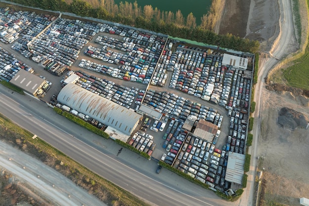 Vista aerea del grande parcheggio della discarica con file di auto rotte scartate Riciclaggio di vecchi veicoli