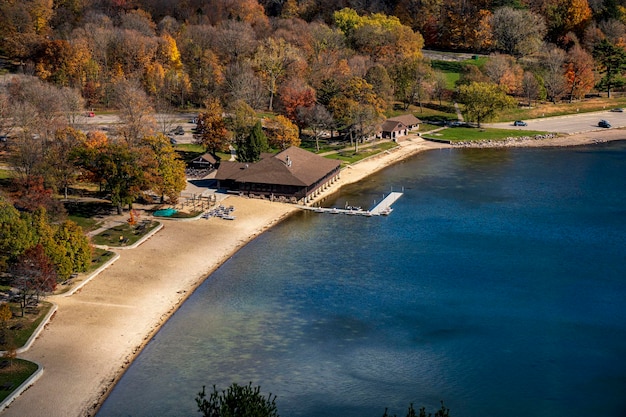 Vista aerea del Lago del Diavolo con alberi di costa ed edifici in autunno vicino a Baraboo, Wisconsin