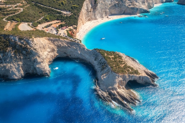 Vista aerea del mare blu montagne spiaggia di sabbia bianca all'alba in estate Porto Katsiki isola di Lefkada Grecia Bellissimo paesaggio con mare costa yacht rocce acqua azzurra foresta verde Vista dall'alto