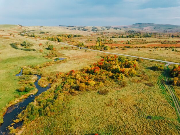 Vista aerea del paesaggio autunnale con colline e colori giallo brillante delle foglie che cadono.