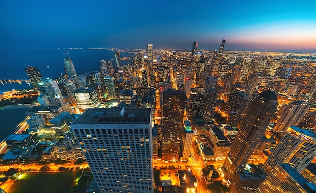 Vista aerea del paesaggio urbano illuminato e del mare al crepuscolo