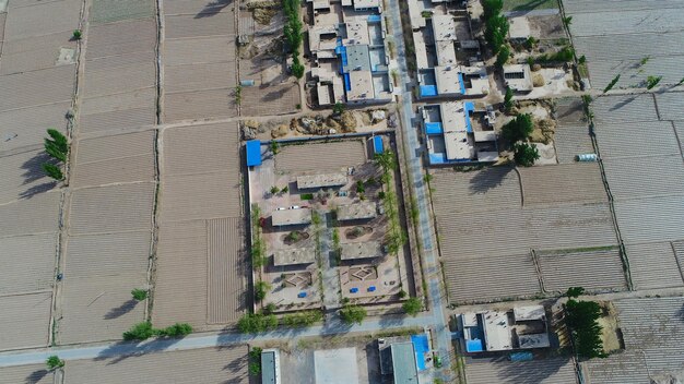 Vista aerea del piccolo villaggio povero con la scuola nel mezzo della terra asciutta della fattoria Gansu Cina