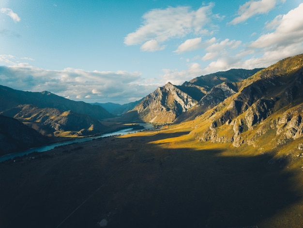 Vista aerea del pittoresco paesaggio di montagna autunnale con il fiume. Colpo di drone