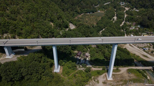 Vista aerea del ponte alto e della strada di montagna con auto e camion, Mar Nero, Russia