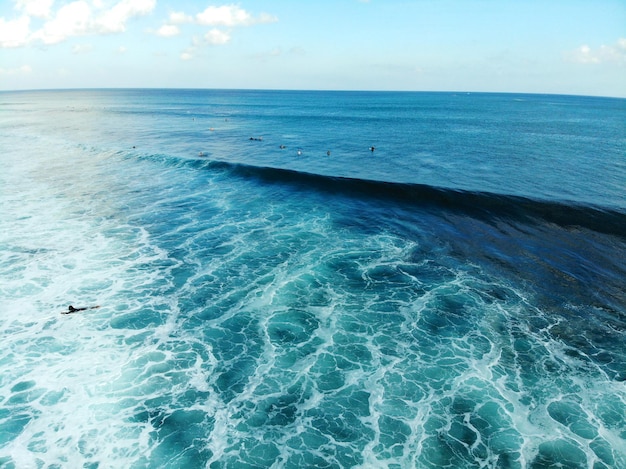 Vista aerea del surfista sulle onde surfisti sulla loro tavola in attesa delle grandi onde