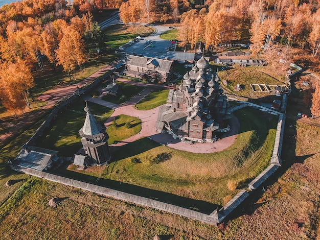 Vista aerea del teologo di legno della vecchia proprietà terriera della chiesa nella foresta di autunno. Russia, San Pietroburgo.