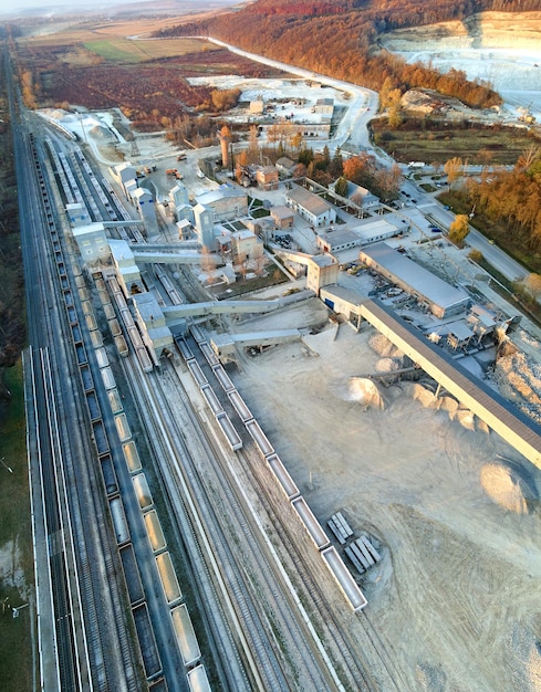 Vista aerea del treno merci caricato con materiali pietrisco presso la fabbrica mineraria. Trasporto ferroviario di minerale di calcare macinato