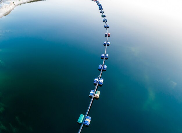 Vista aerea del tubo blu con barili sul profondo lago blu navy