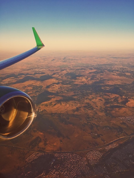 Vista aerea dell'ala di un aereo sul paesaggio contro il cielo