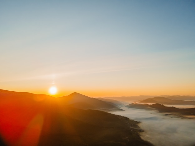 Vista aerea dell'alba sopra lo spazio della copia della catena montuosa