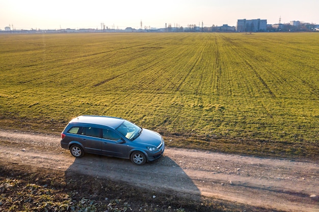 Vista aerea dell'automobile che guida dalla strada a terra diritta attraverso verde