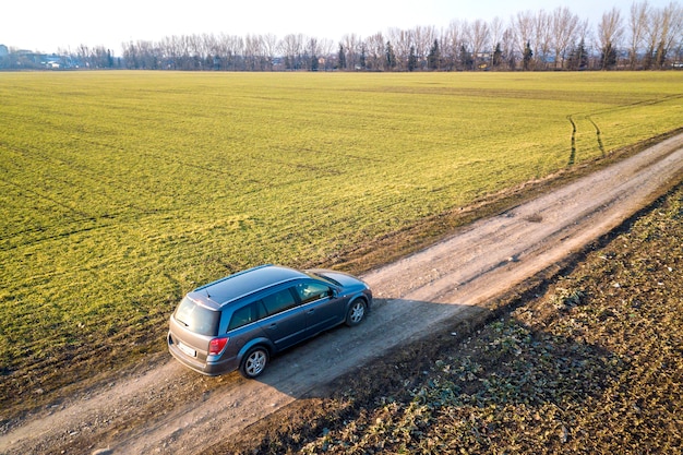 Vista aerea dell'automobile che guida dalla strada a terra diritta attraverso verde