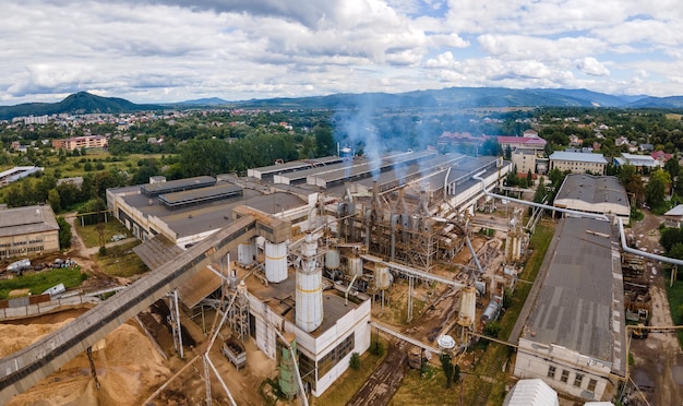Vista aerea dell'impianto di lavorazione del legno con ciminiera dall'ambiente inquinante del processo di produzione nel cantiere di produzione della fabbrica