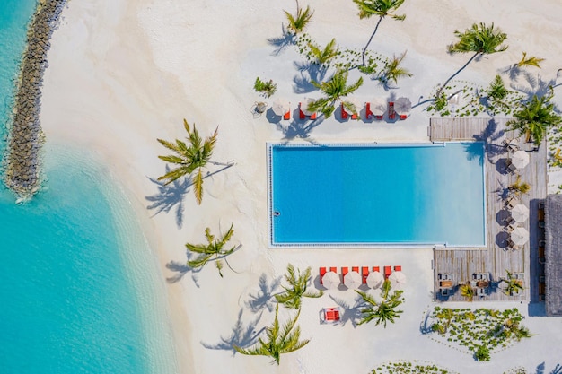 Vista aerea dell'isola delle Maldive, resort di ville sull'acqua di lusso e molo in legno. Bellissimo cielo e oceano