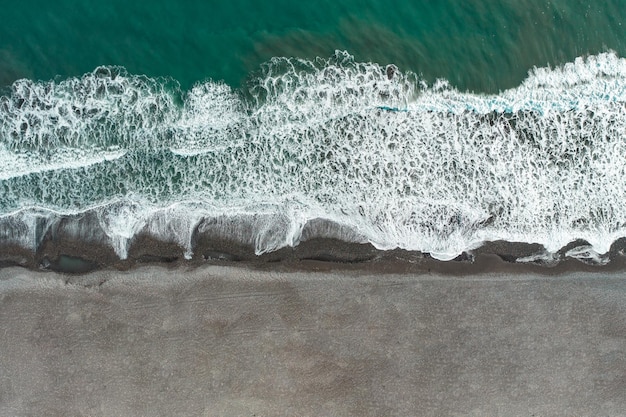 Vista aerea dell'oceano cileno con spiaggia di sabbia nera Vista dall'alto dal drone